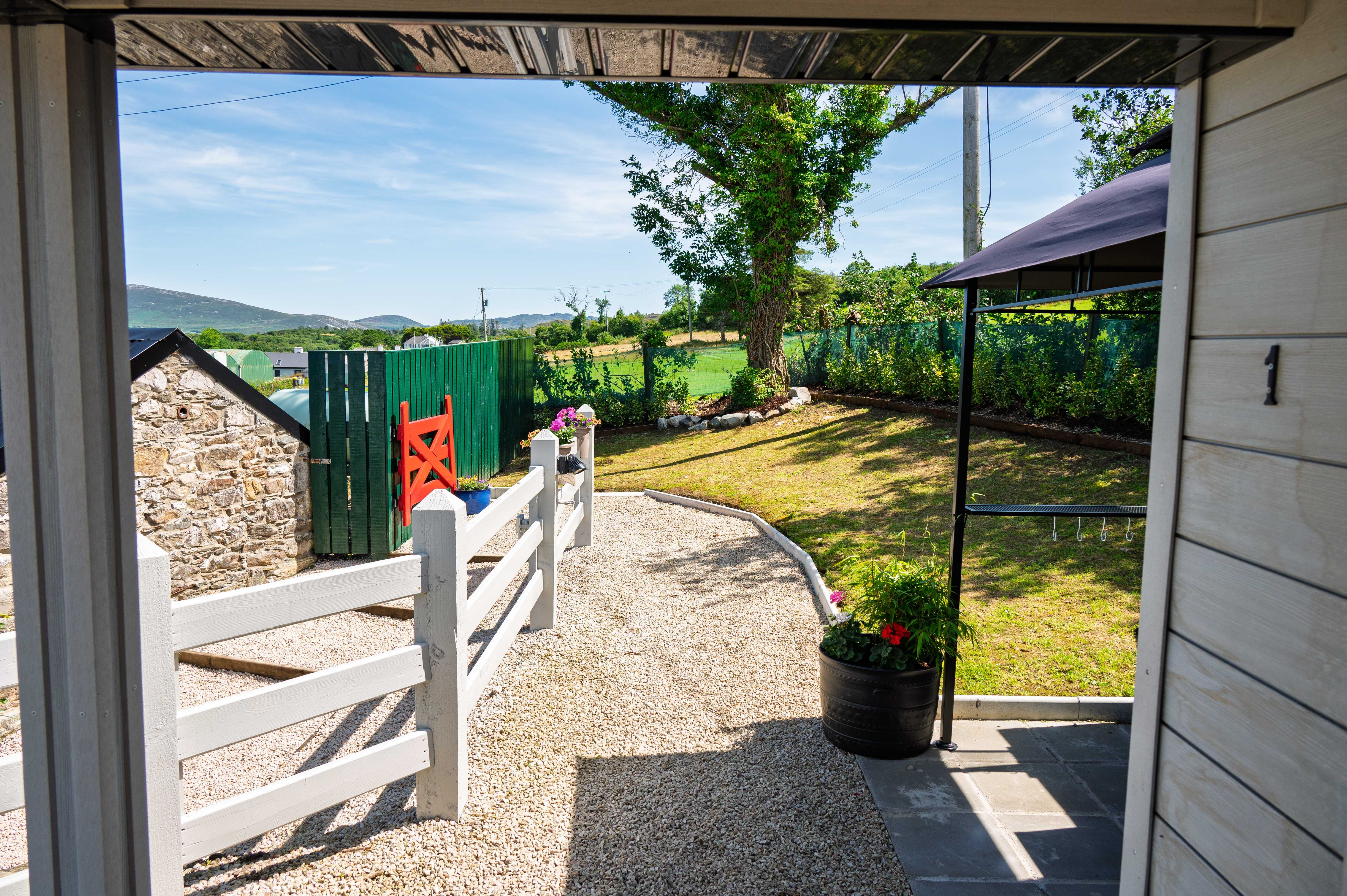 The view out from under Rae’s covered porch, toward the cottage and the bay