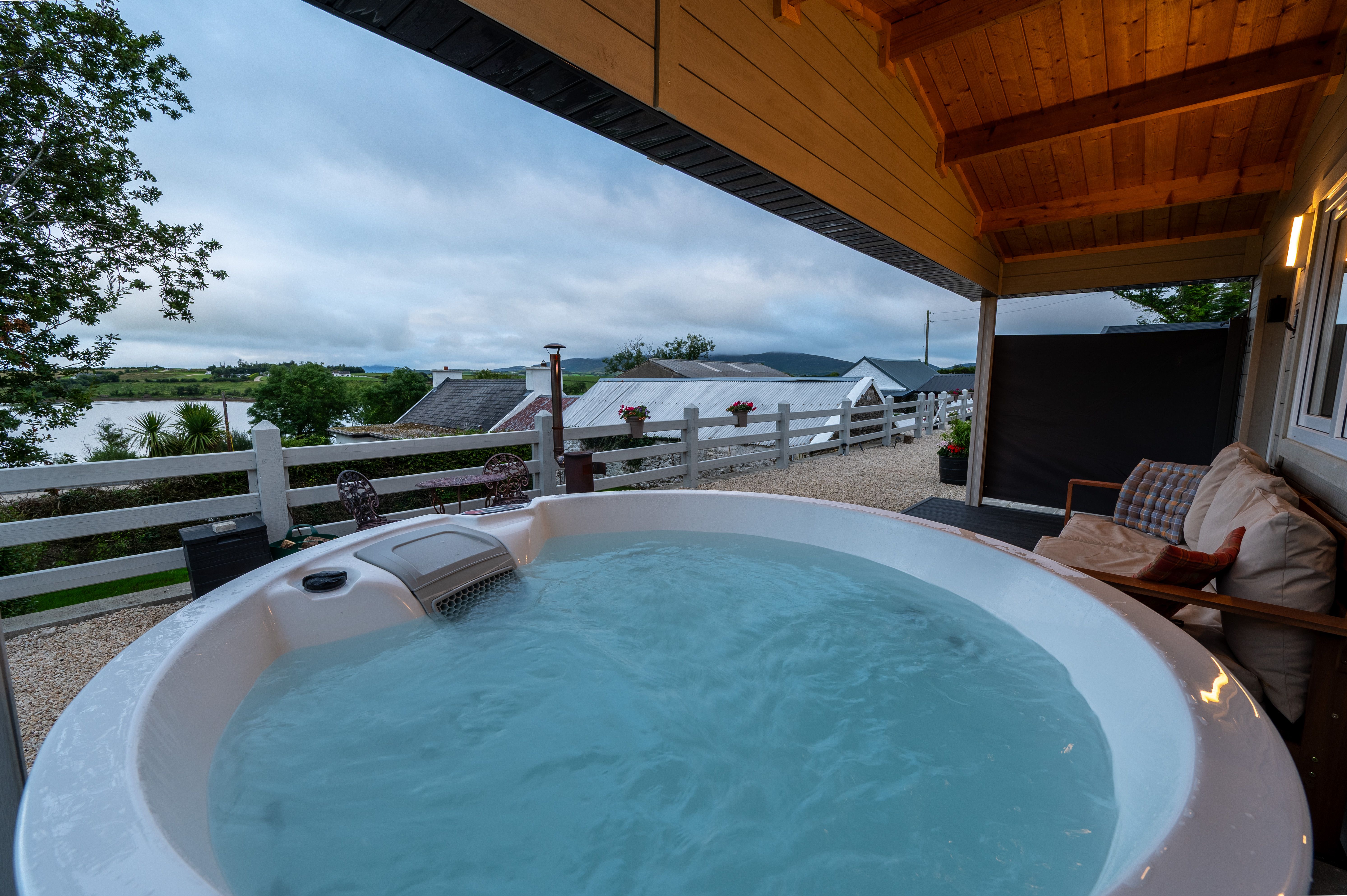 Cabin One's hot tub with Mulroy Bay and the cordyline palms beyond
