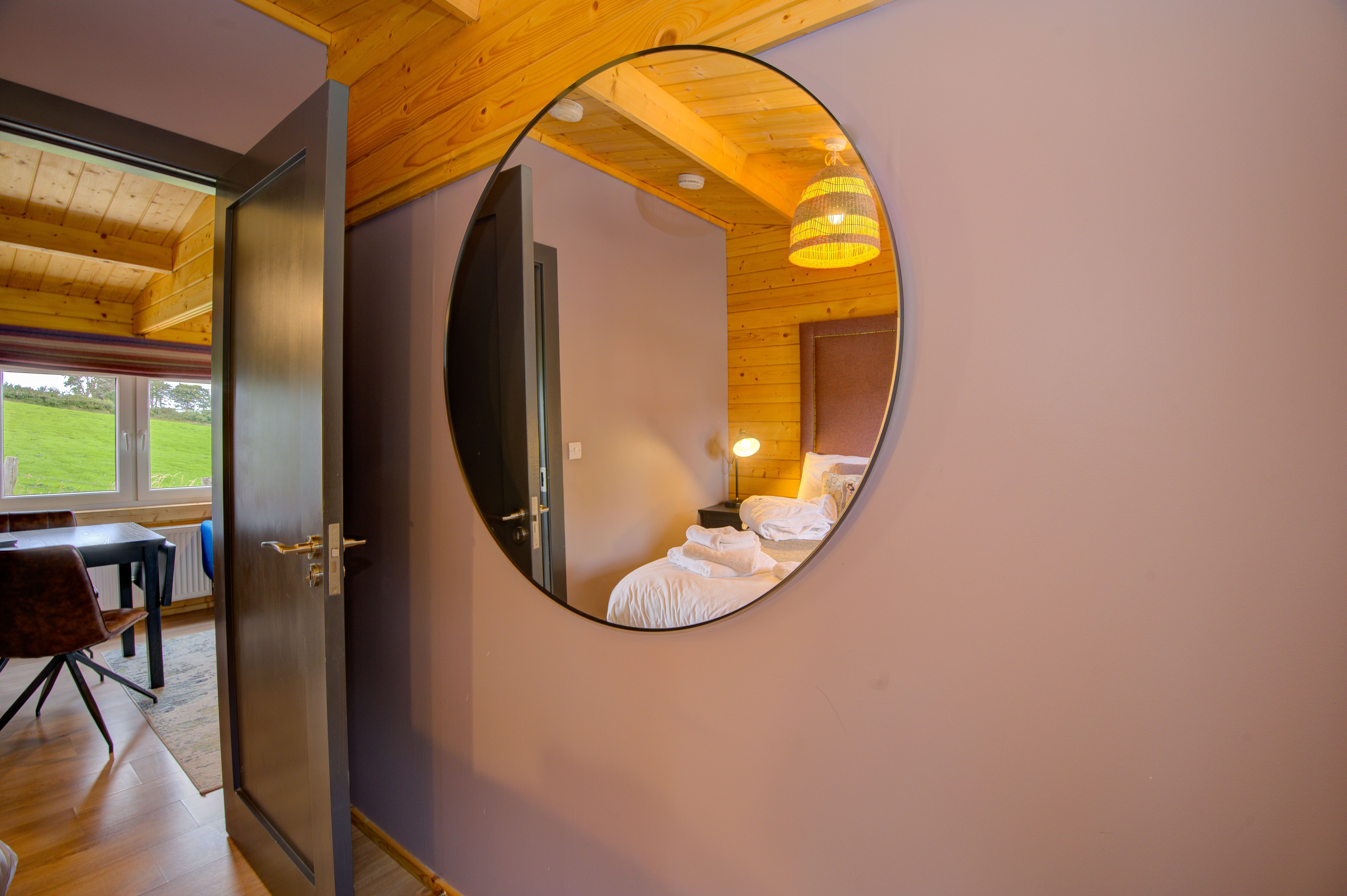Margaret’s hallway with a round mirror reflecting the bedroom