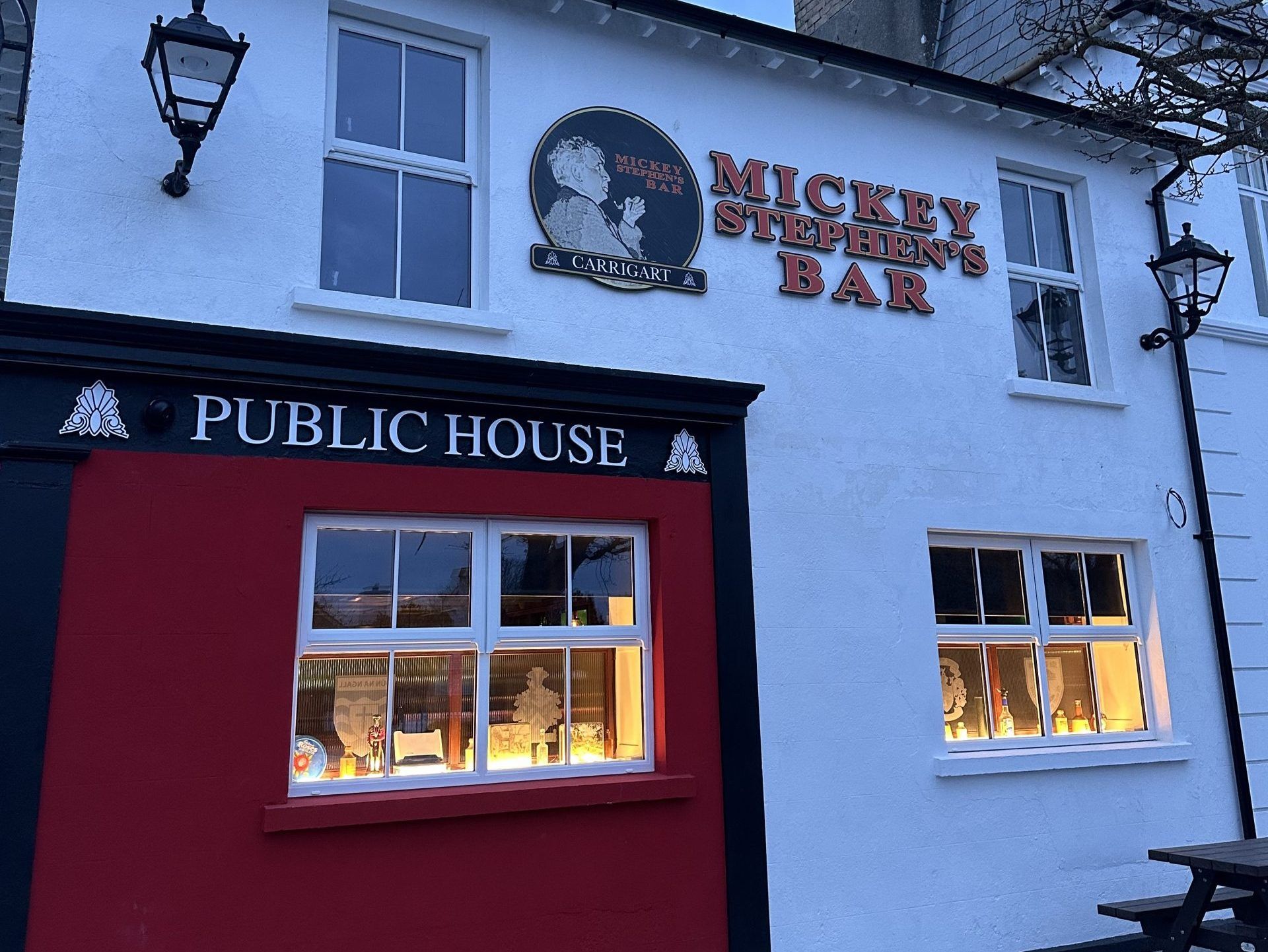 The Mickey Stephen’s bar sign at the Carrigart Hotel, lit at dusk