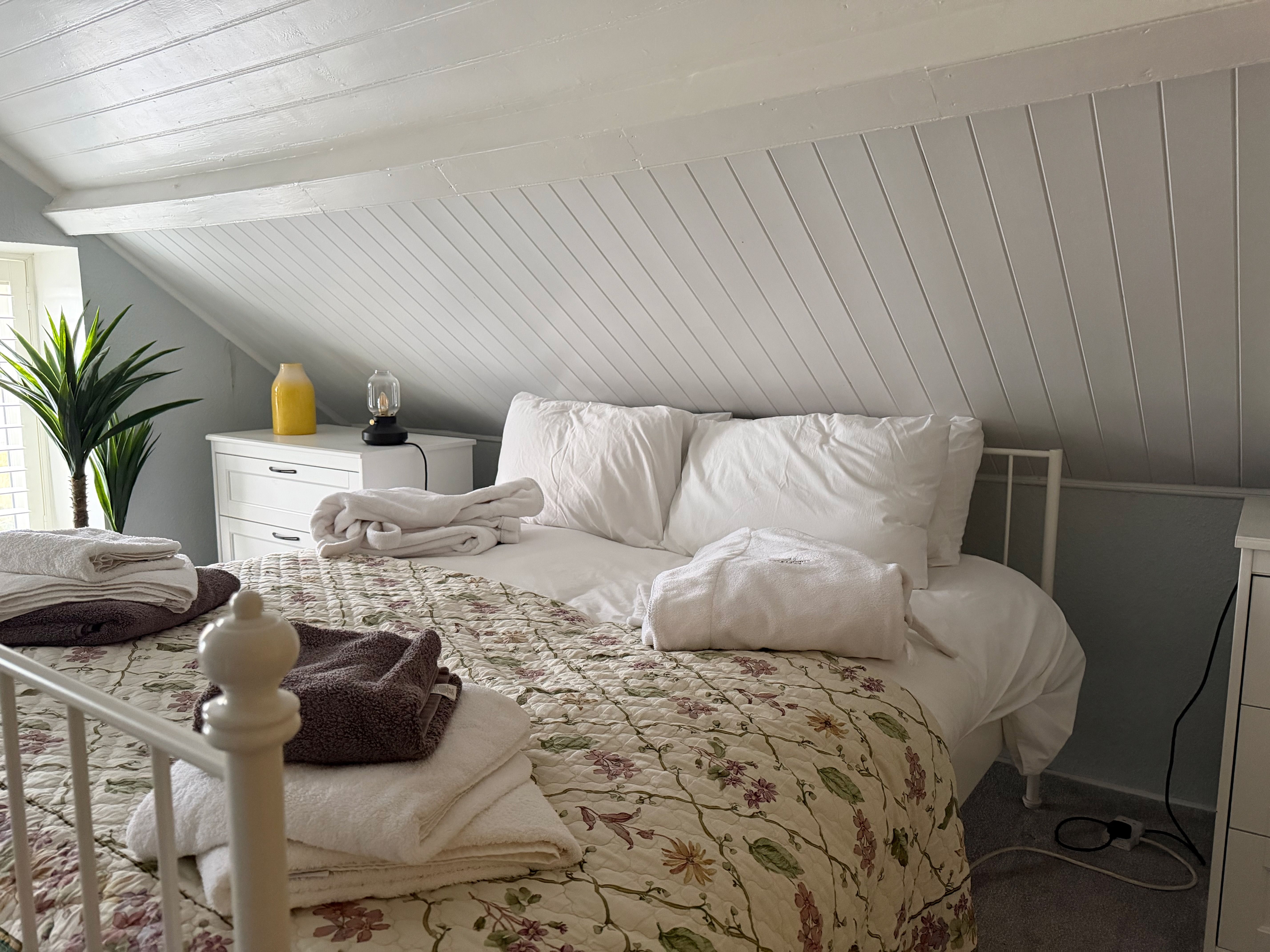 The attic bedroom, its sloped ceiling re-lined in tongue-and-groove and freshly painted