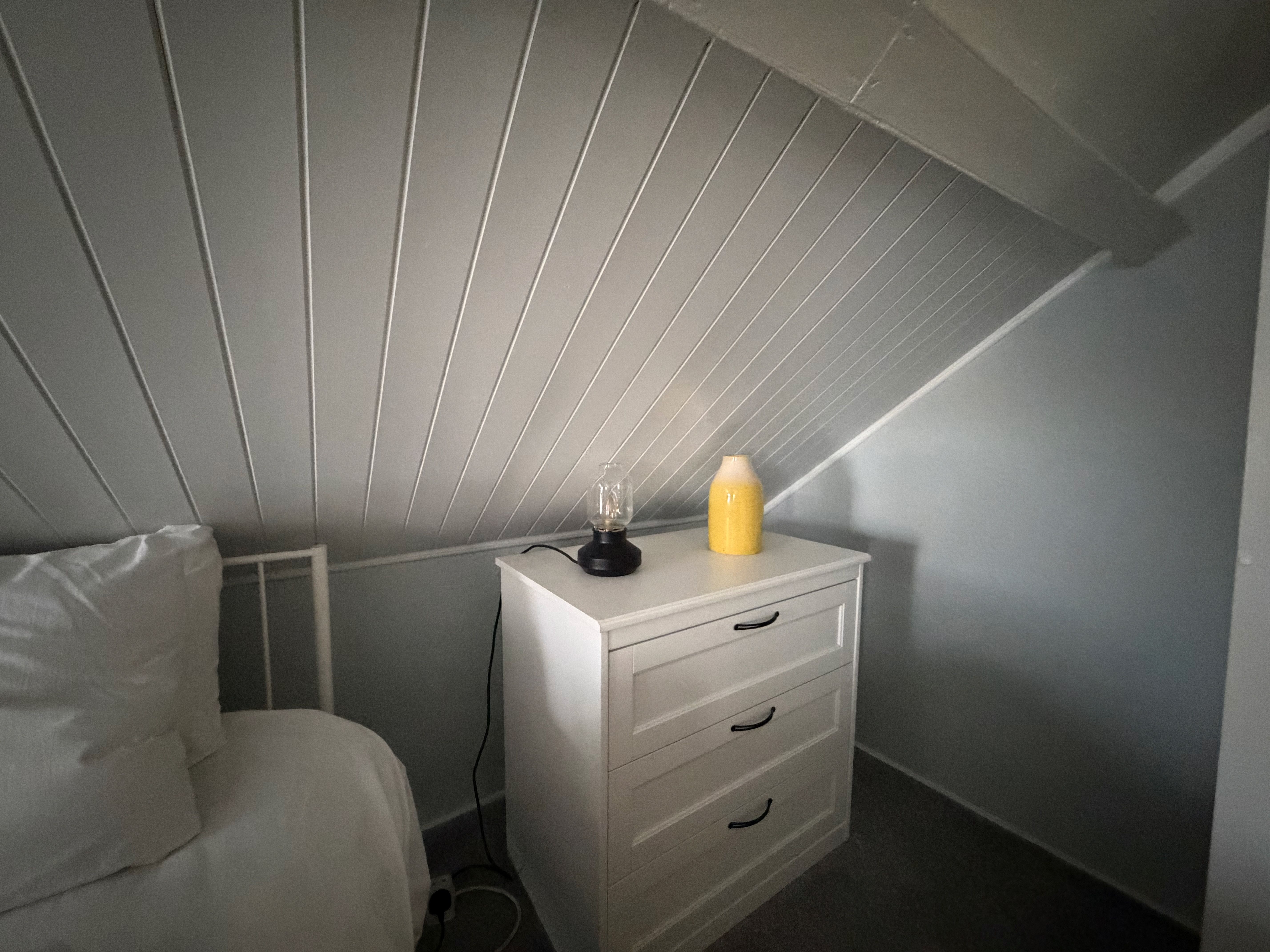 A corner of the redecorated attic bedroom, freshly painted boards