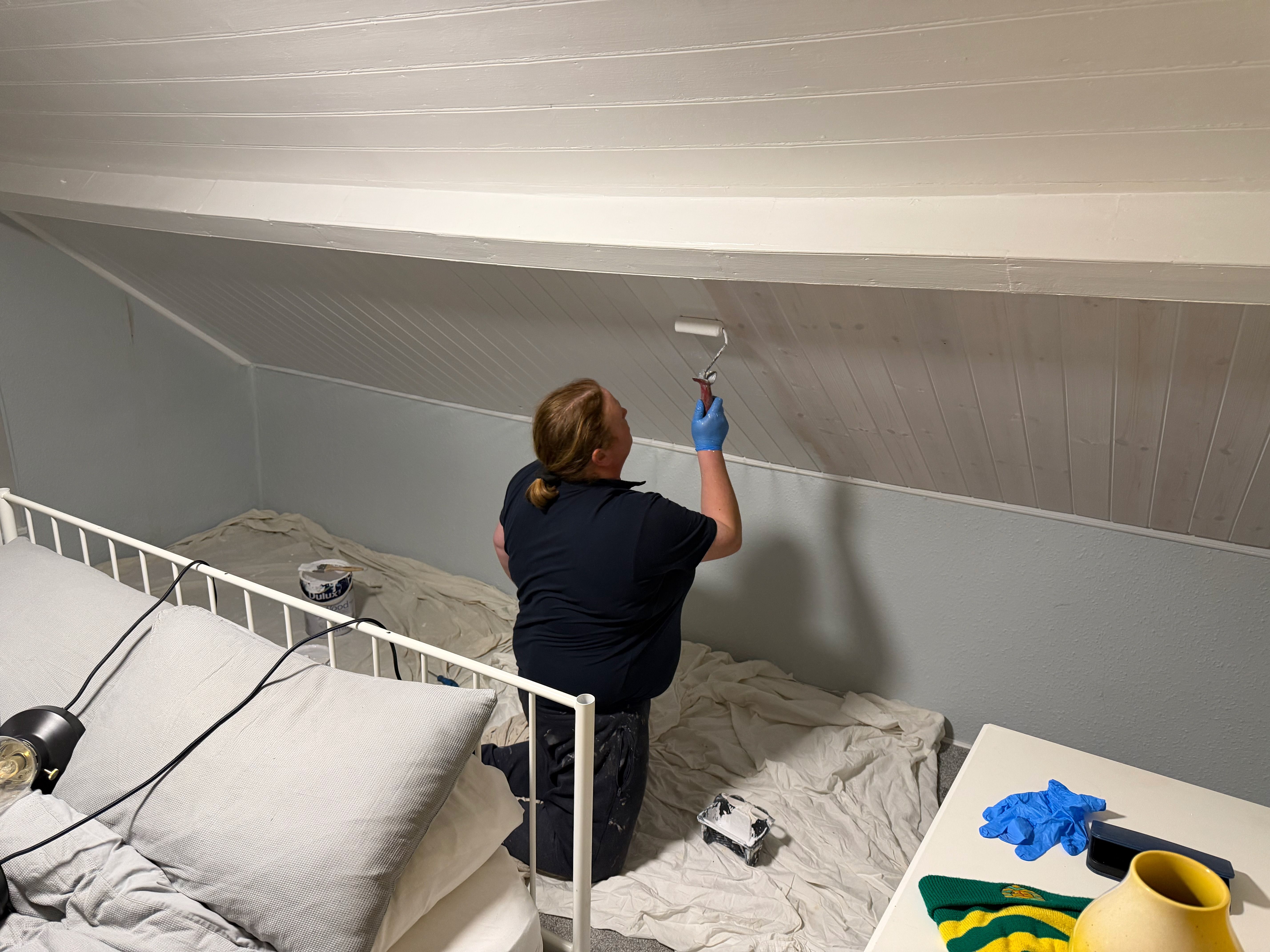 The attic bedroom’s sloped ceiling being repainted during the works