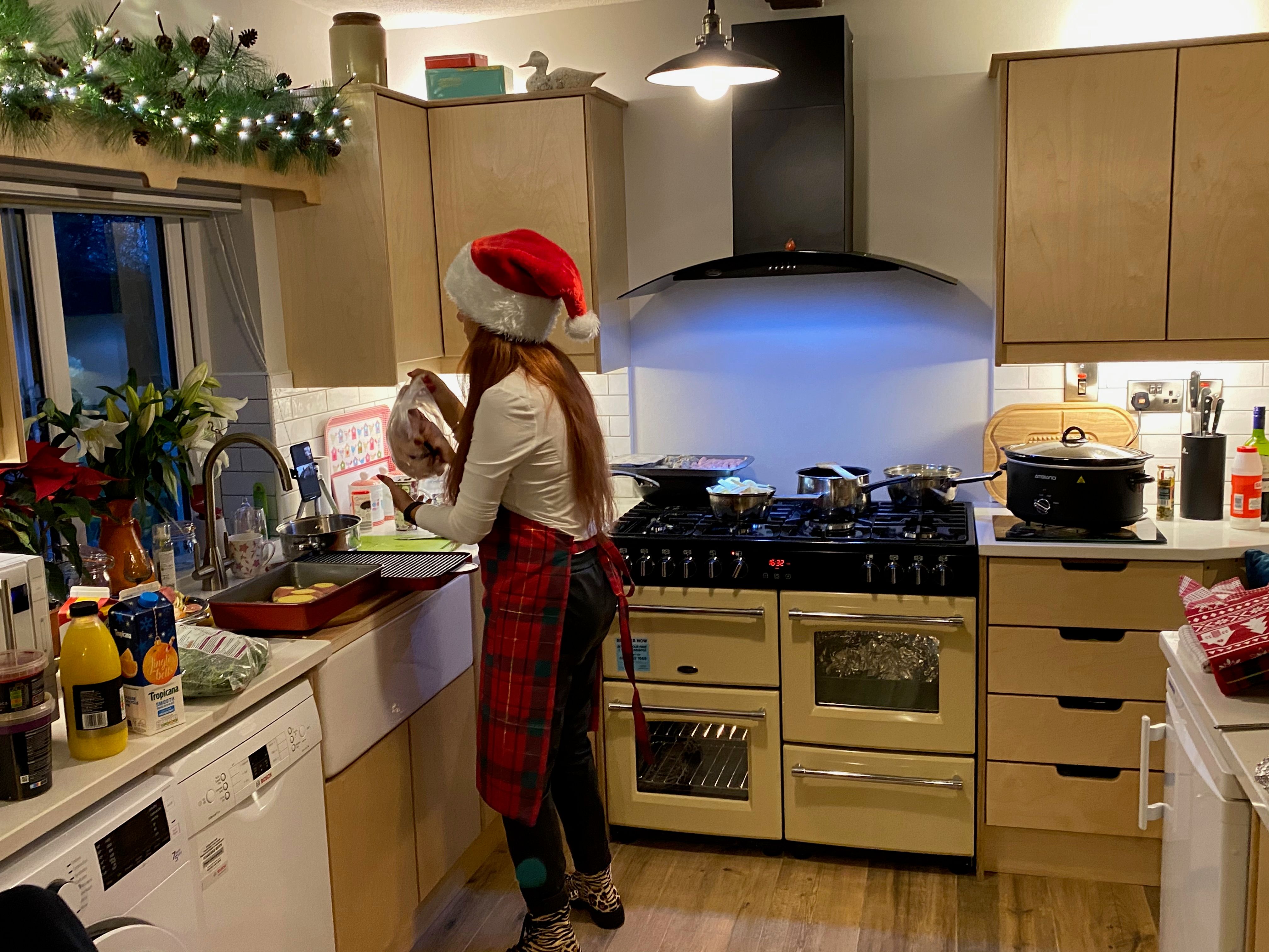 The cottage kitchen on Christmas day, the cook at the range under the exposed beam, the stone wall alongside.