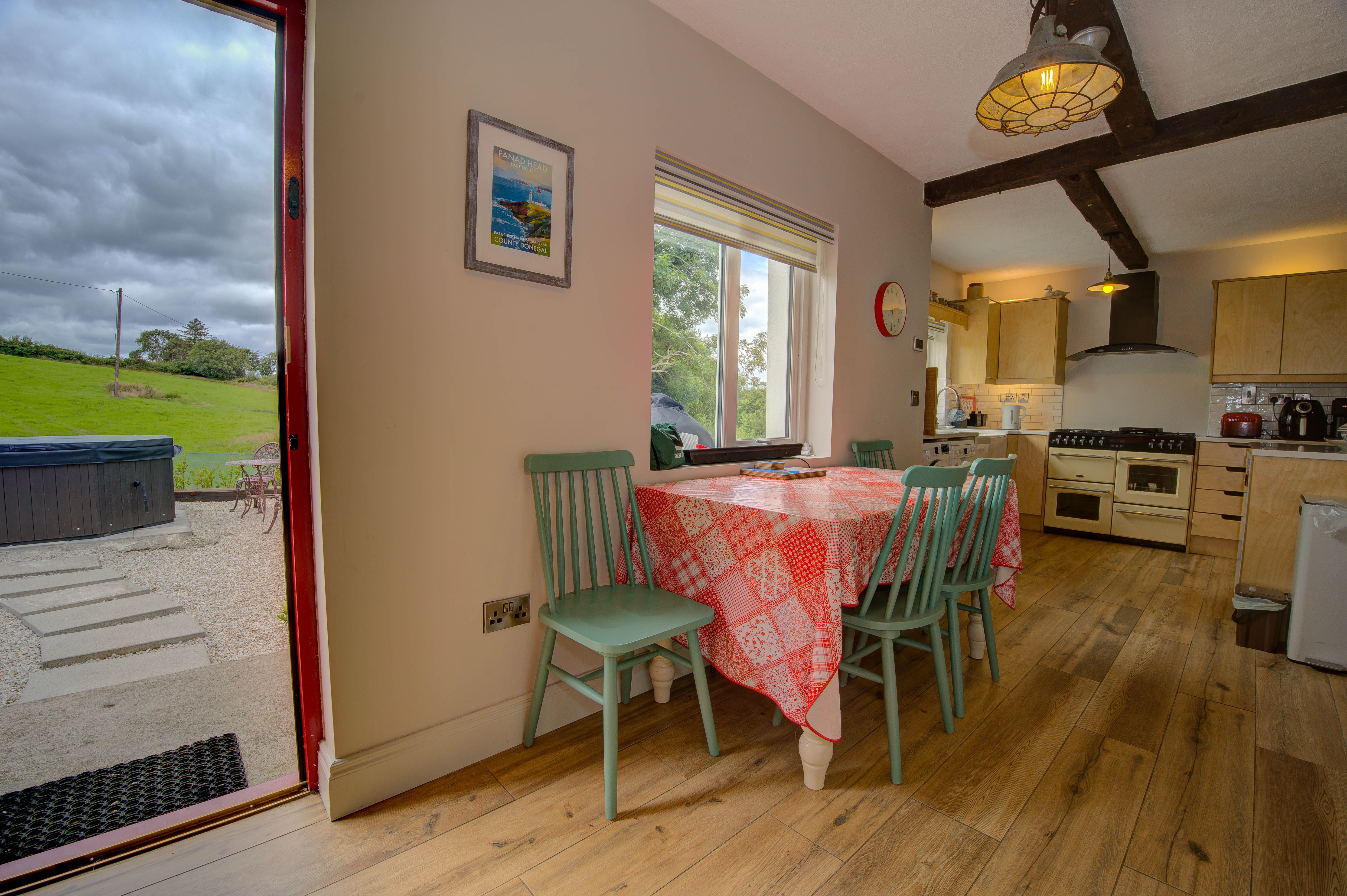 The cottage kitchen seen from the dining room, with the cream range beyond the doorway