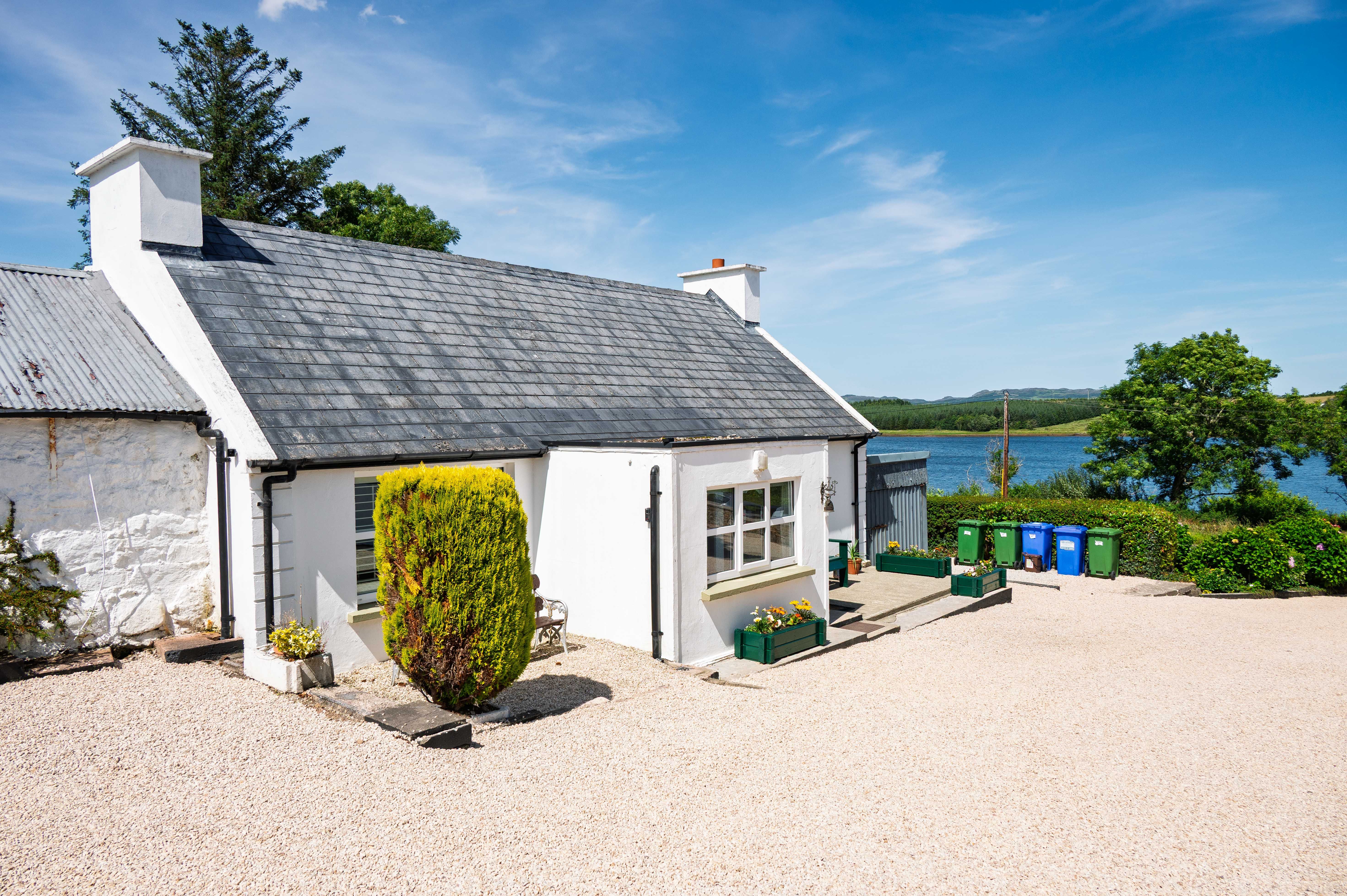 The finished cottage from up the gravel Street, Mulroy Bay reading clearly across the road beyond.