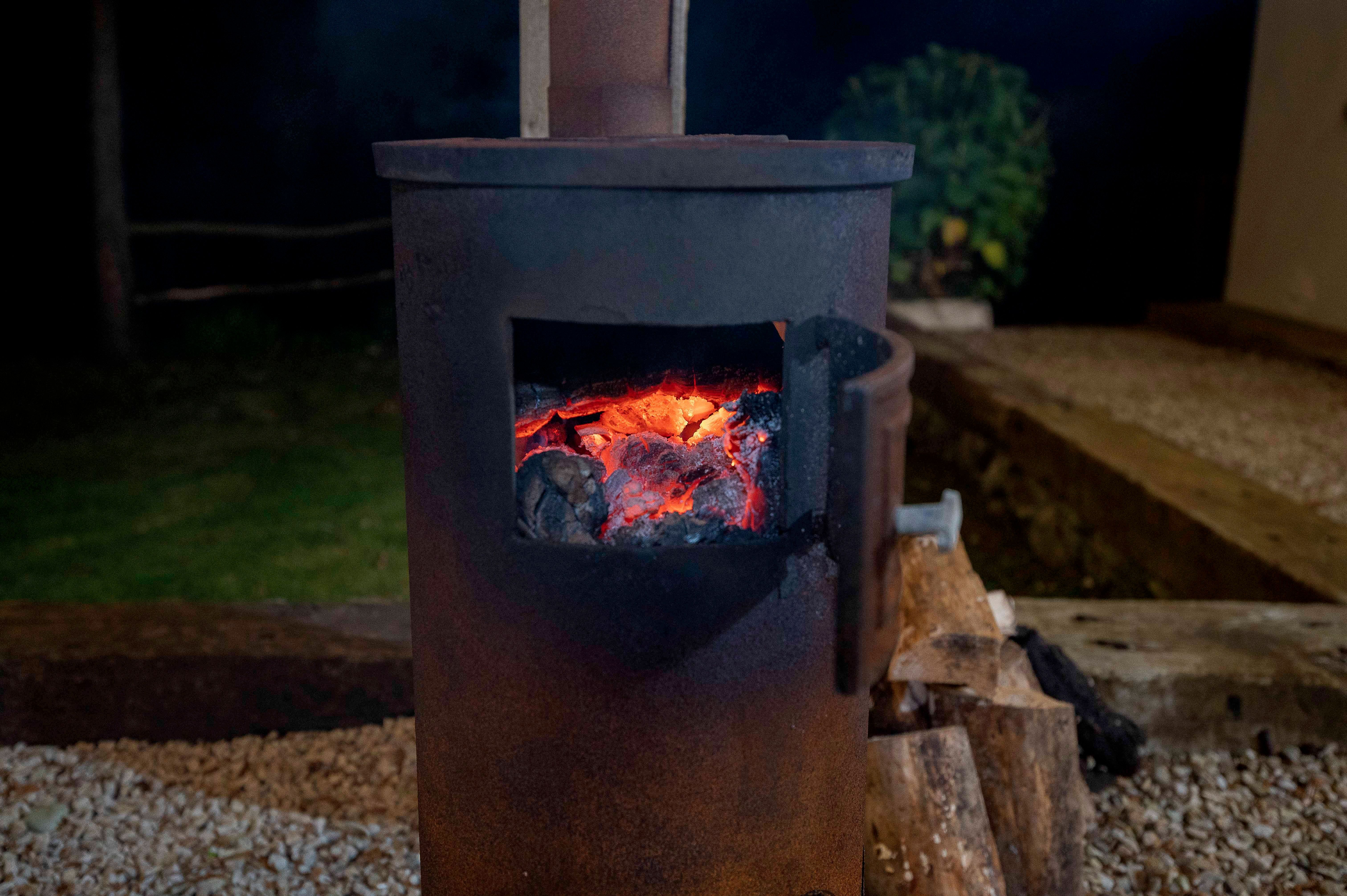 The cast-iron chiminea lit in the cottage garden at night