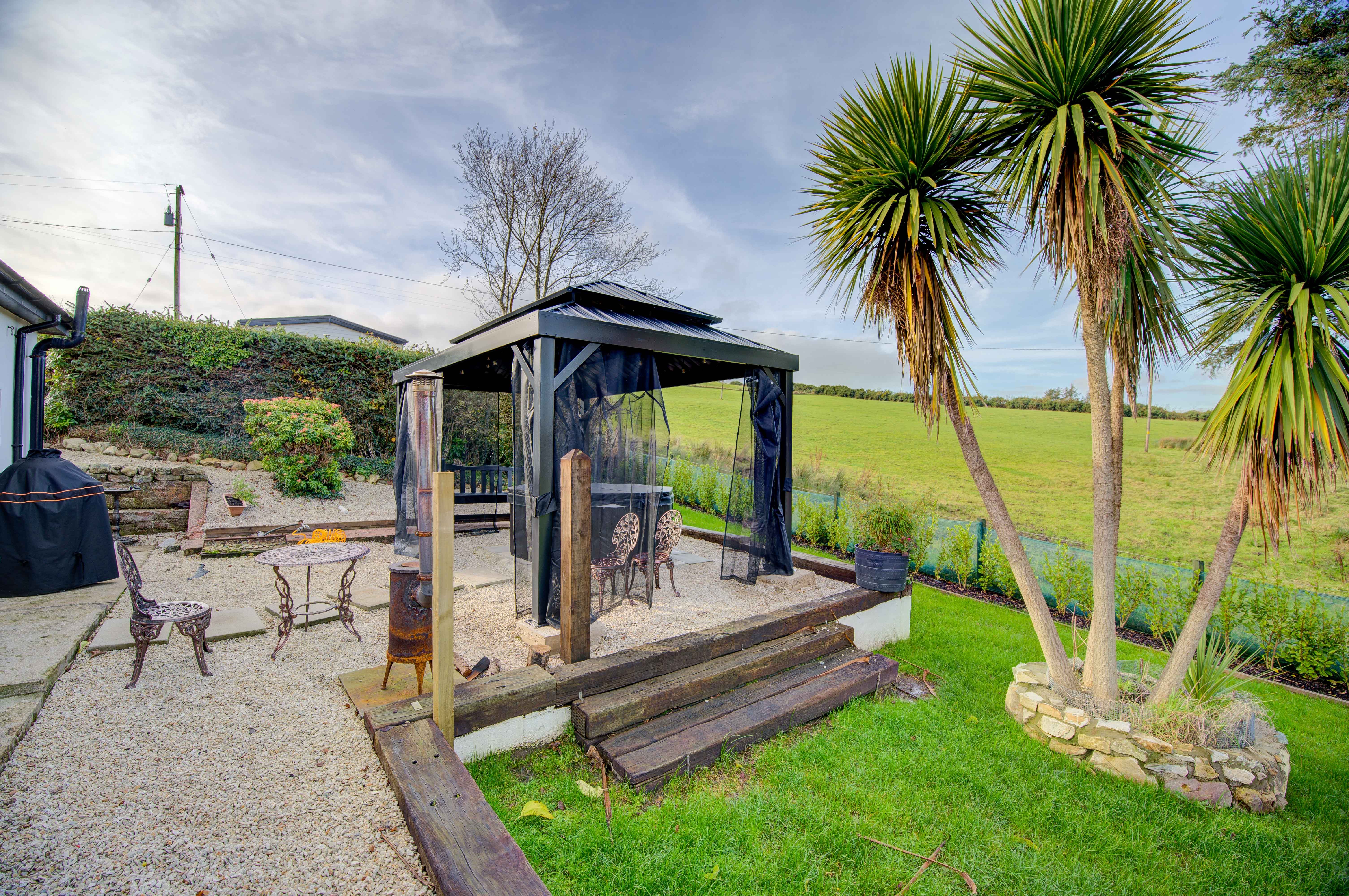 The cottage back garden looking across to the green hillside, palms in the planter