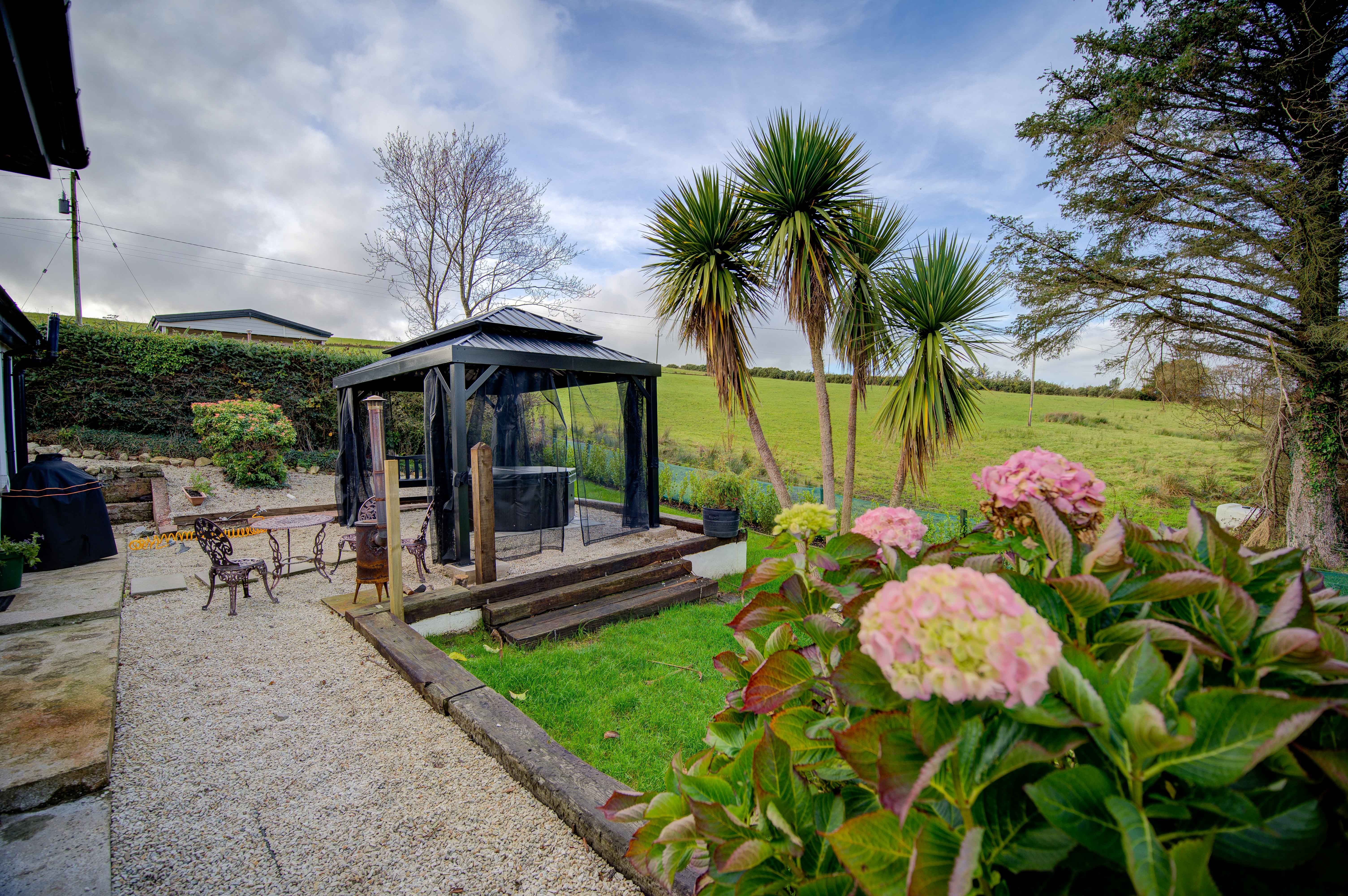 The cottage garden — quartz paving, cordyline palms and the gazebo