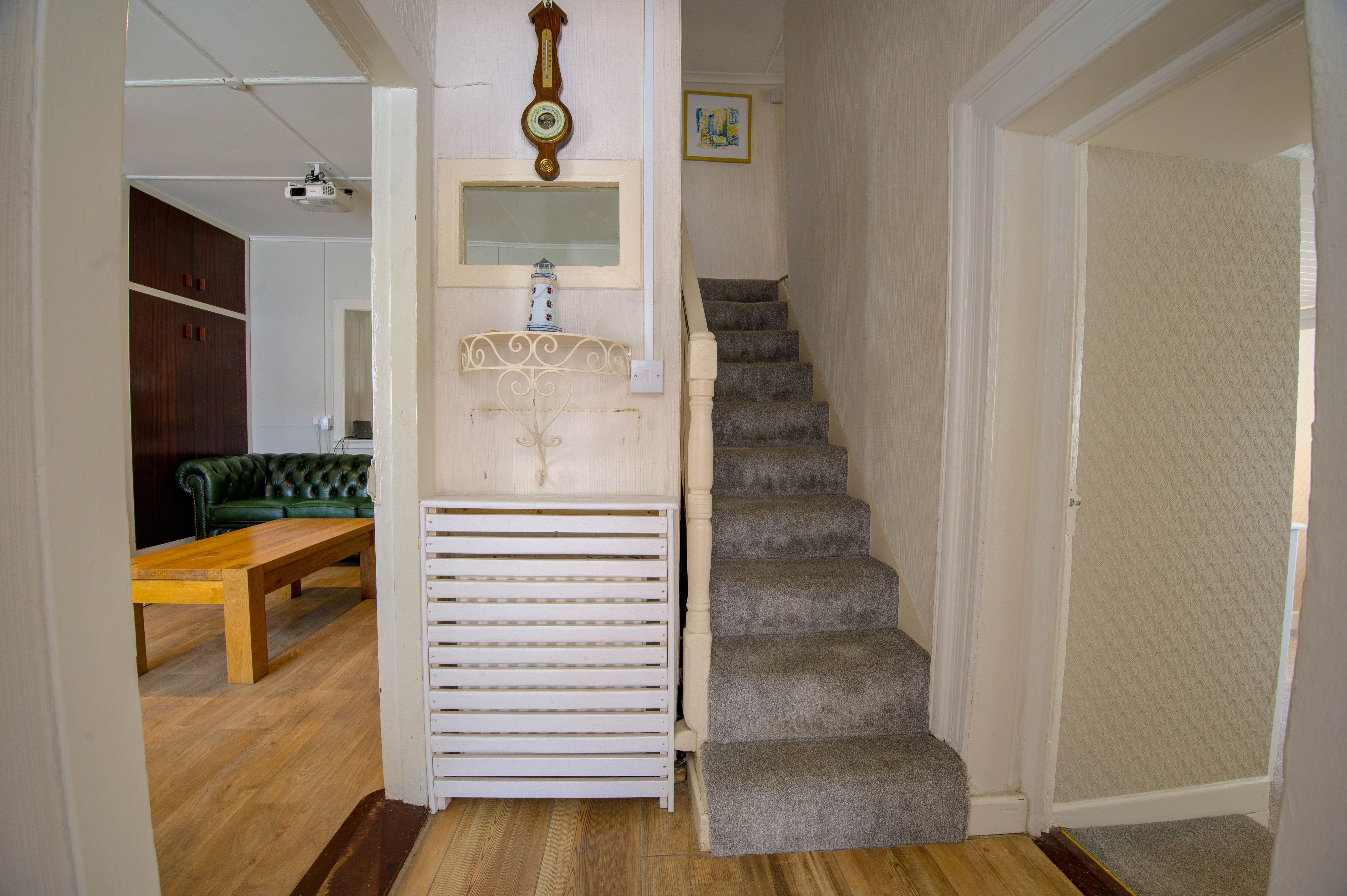 The cottage stairs and hallway, looking from the living area toward the staircase.