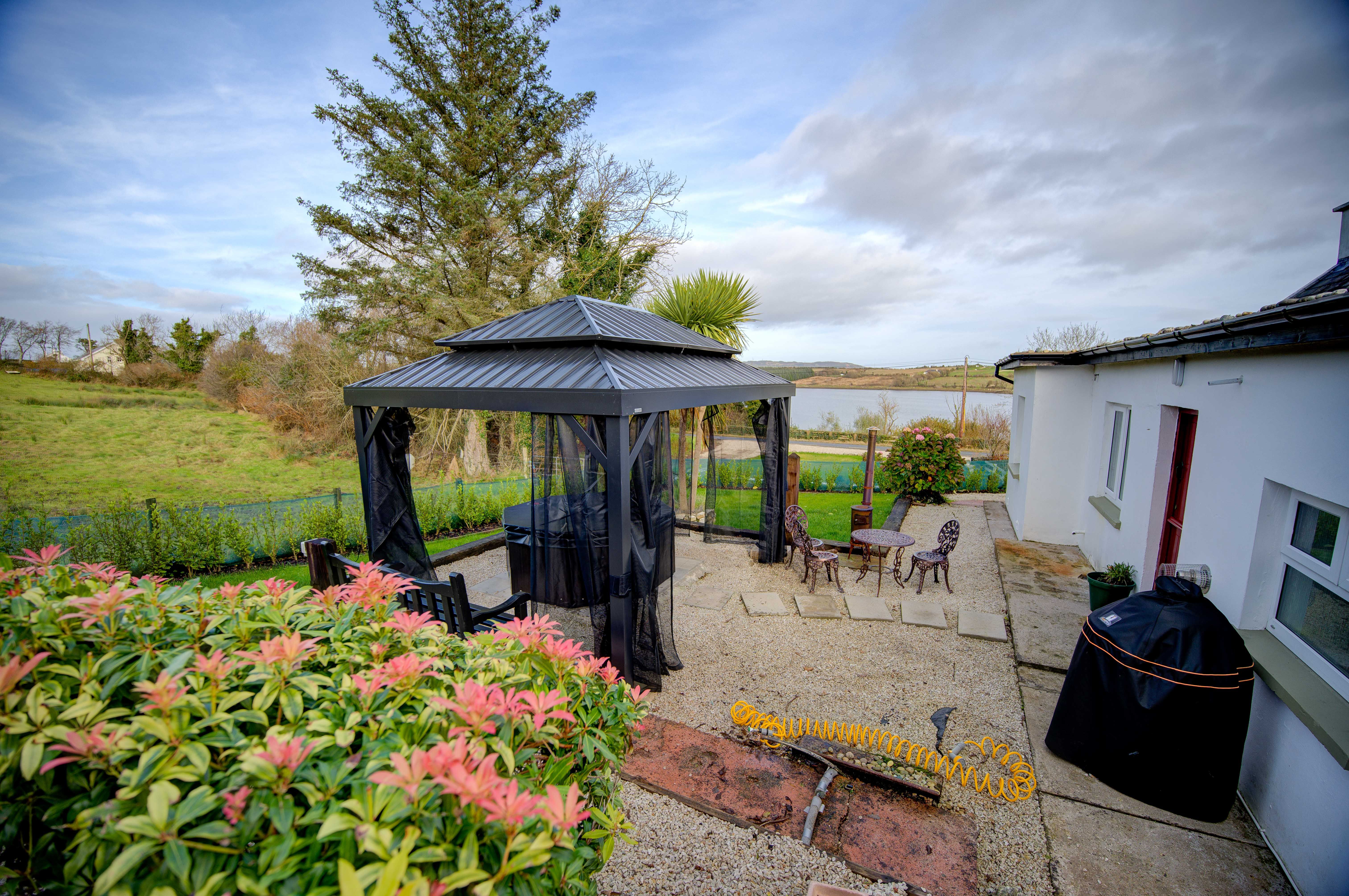 Cast-iron bistro seating on the cottage patio beside the gazebo
