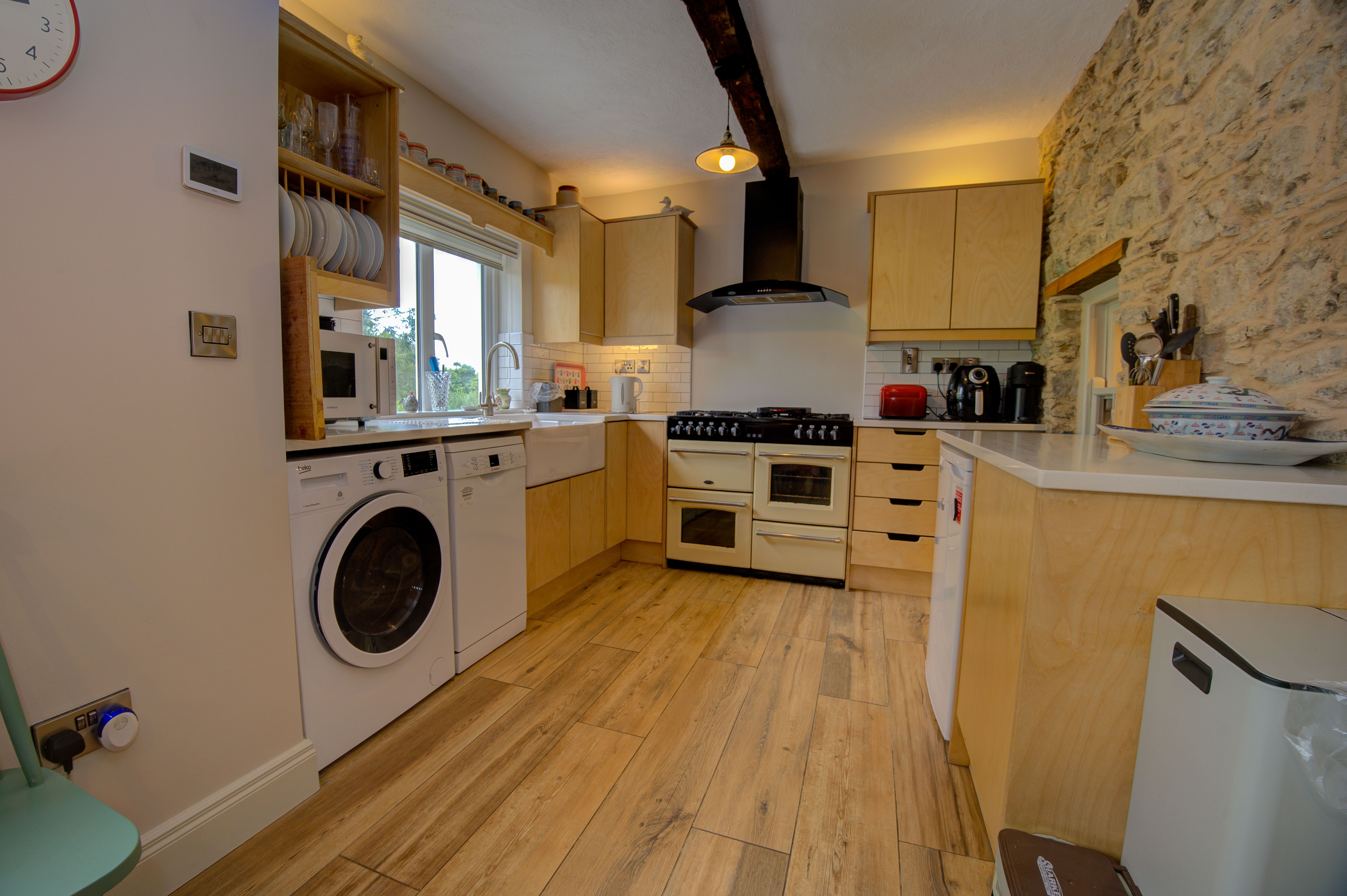 The cottage kitchen with the cream Belling range and exposed stone wall