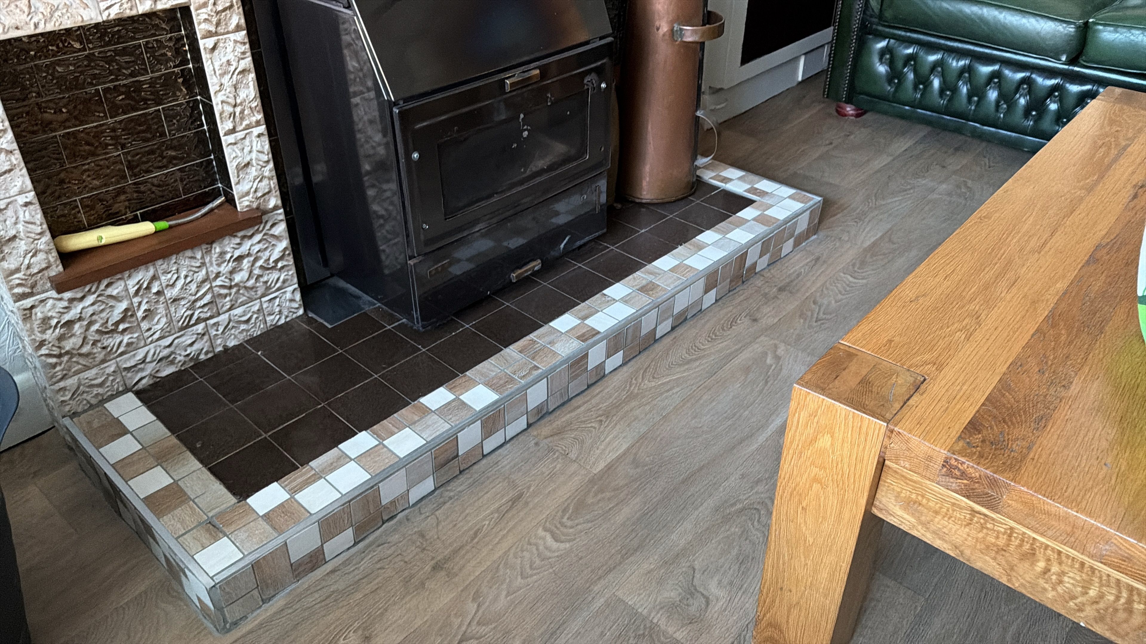 New mosaic-bordered tiling around the sitting-room fireplace