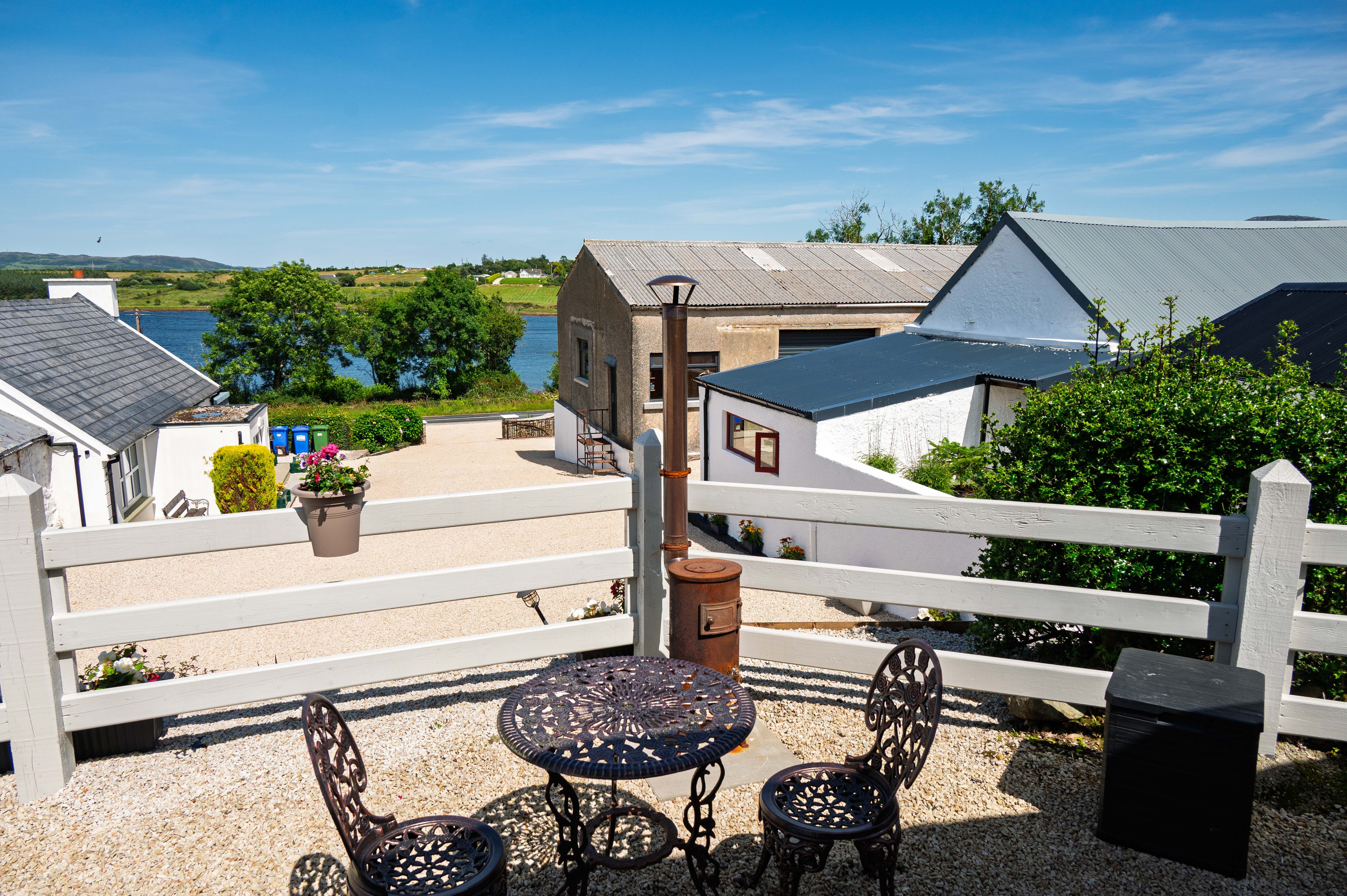 Bistro seating in the sun, looking down across the property to Mulroy Bay — a wellness morning while the rest of the party golfs