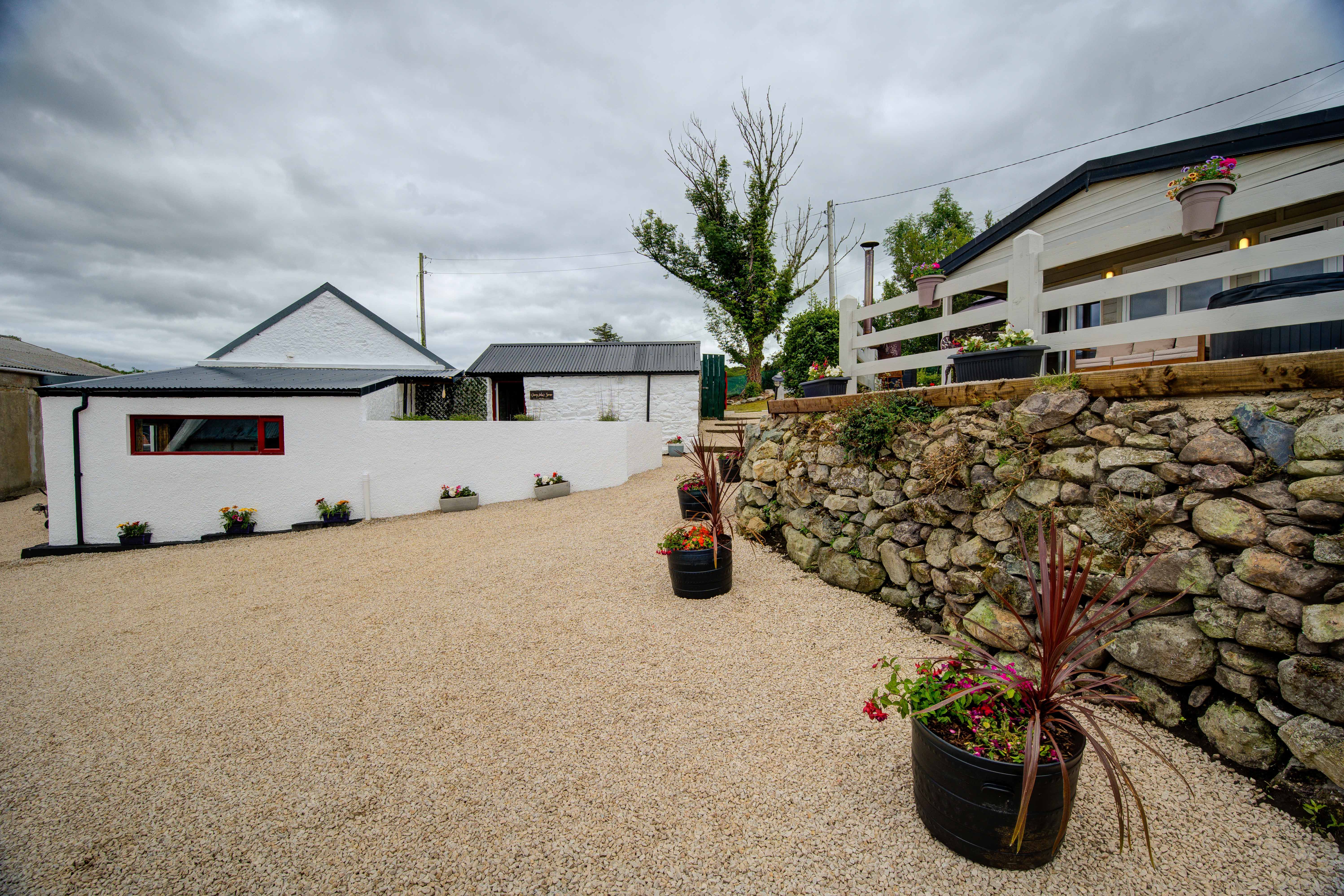 The gravel street between the sauna outbuilding and the cabin terrace