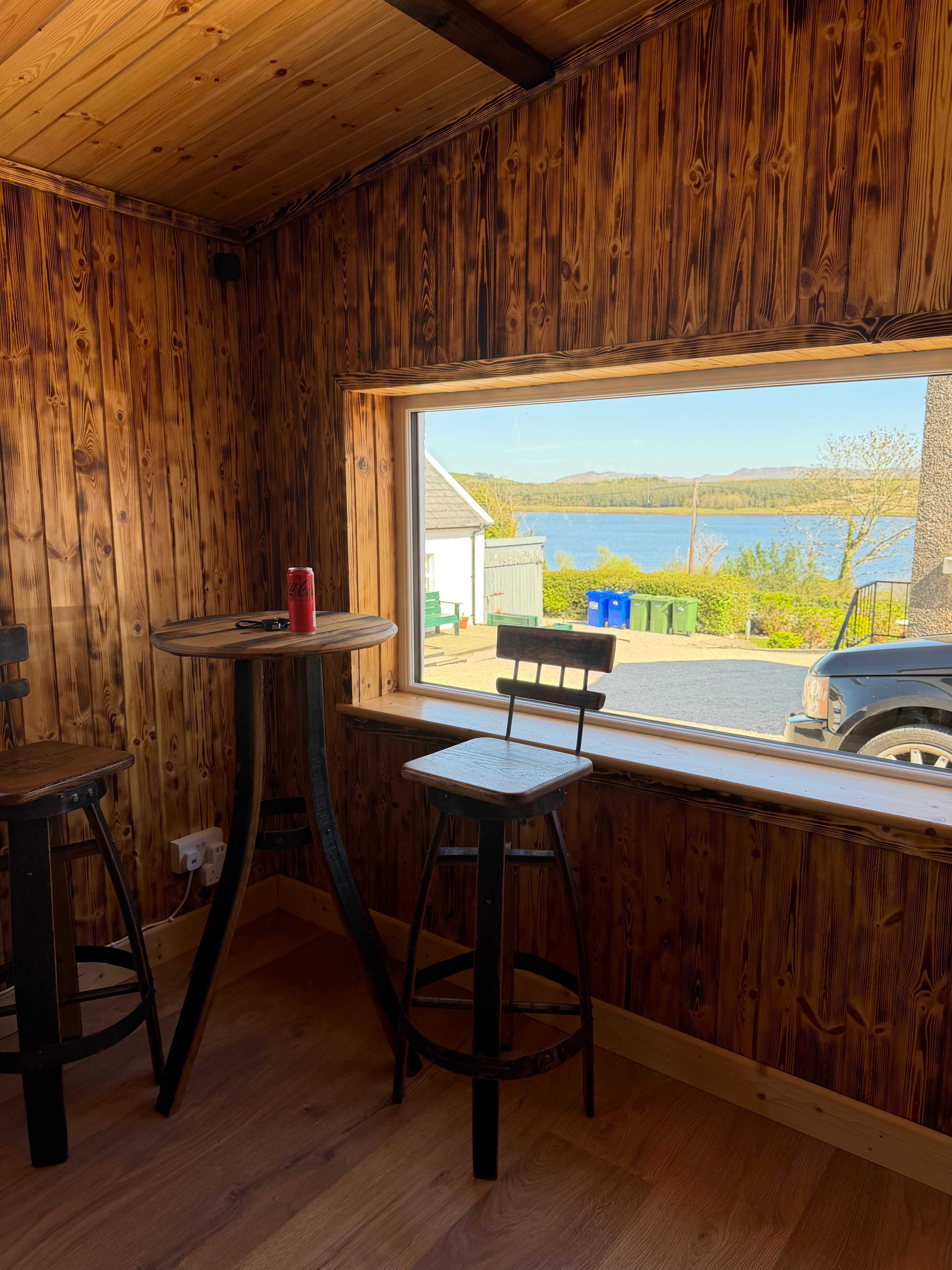 The whiskey-stave bar in the games room, Mulroy Bay through the picture window