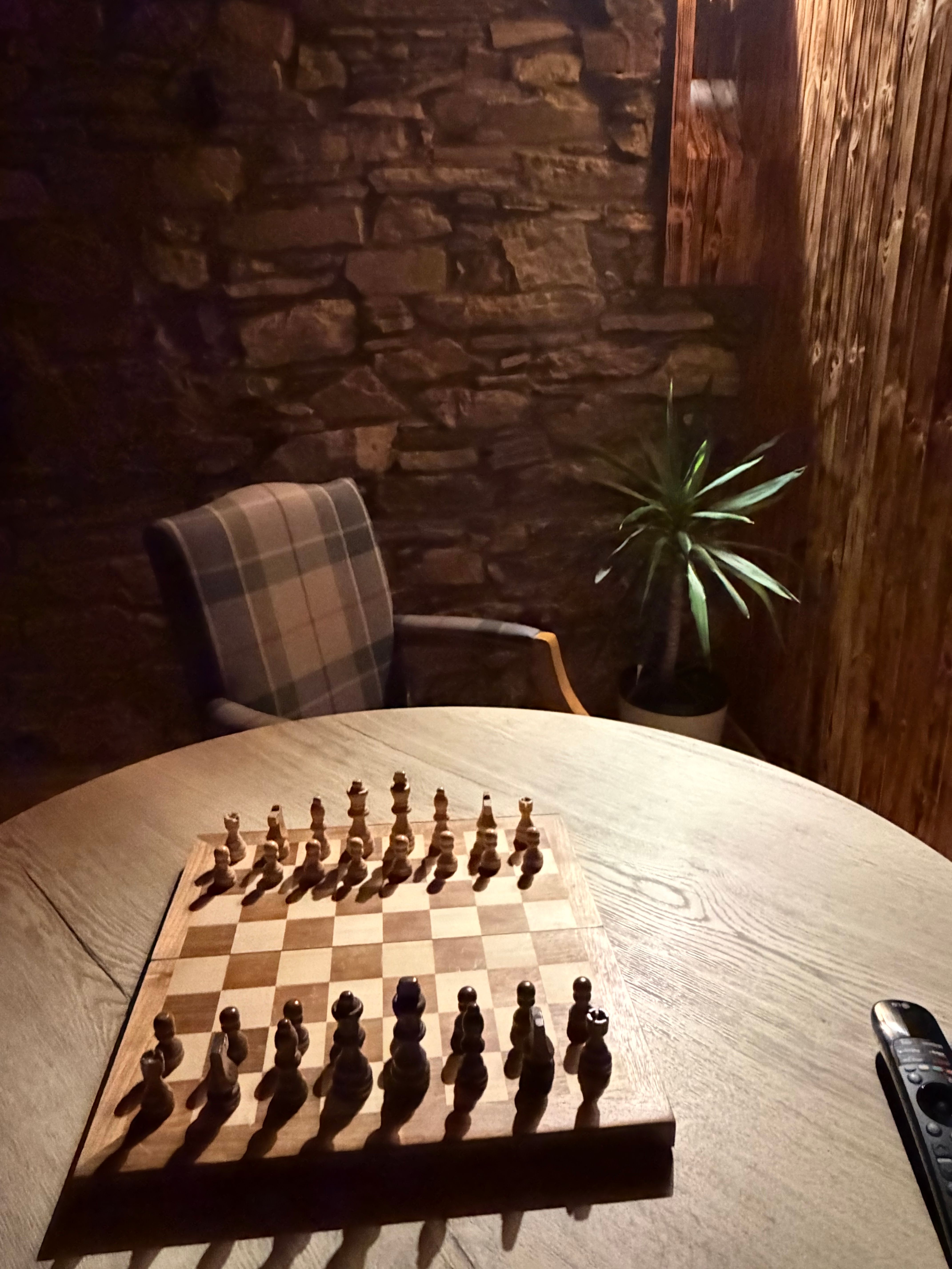 The chess set against the games-room stone wall