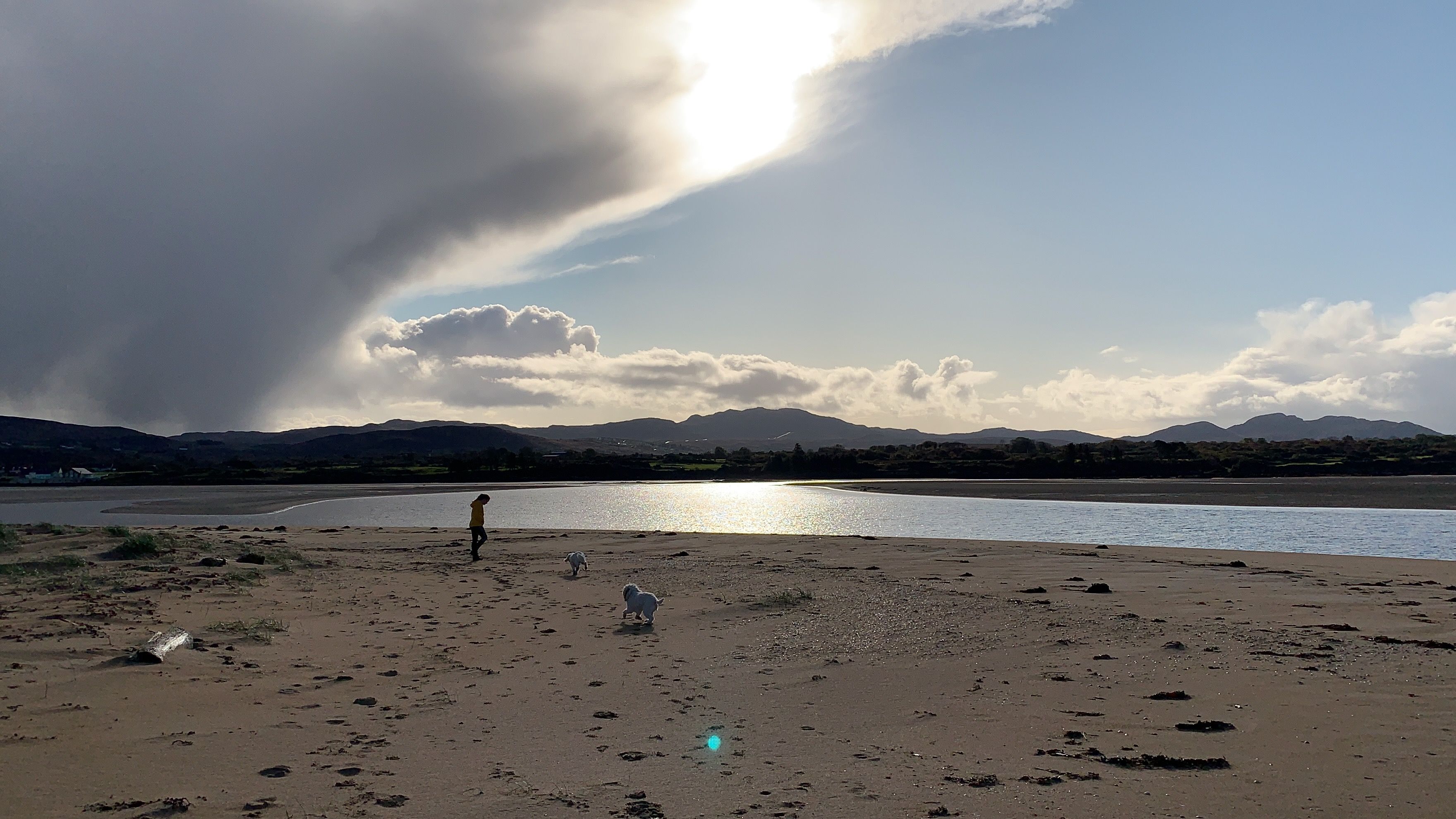 Walking two dogs on the estuary beach near Doe Castle, a dark cloud breaking behind