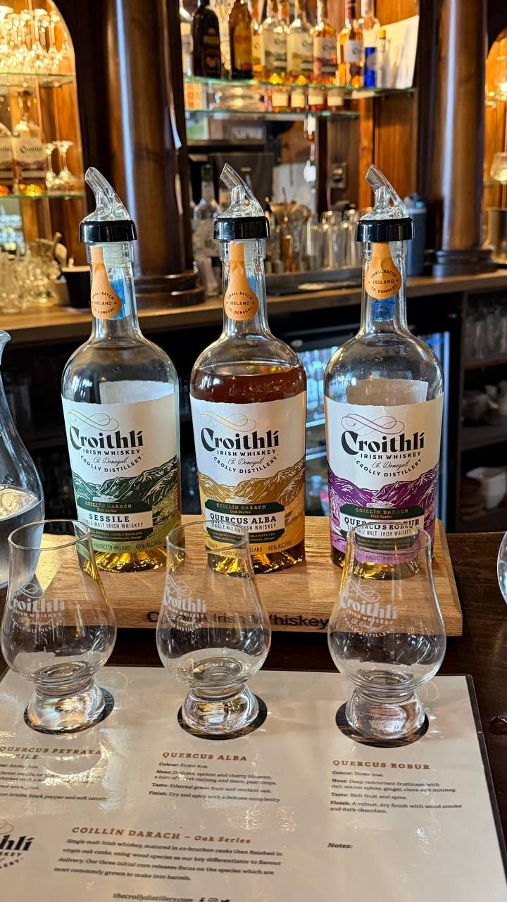 The three Oak Series bottles, Sessile, Quercus Alba and Quercus Robur, on a wooden tasting board above three nosing glasses and the tasting notes.