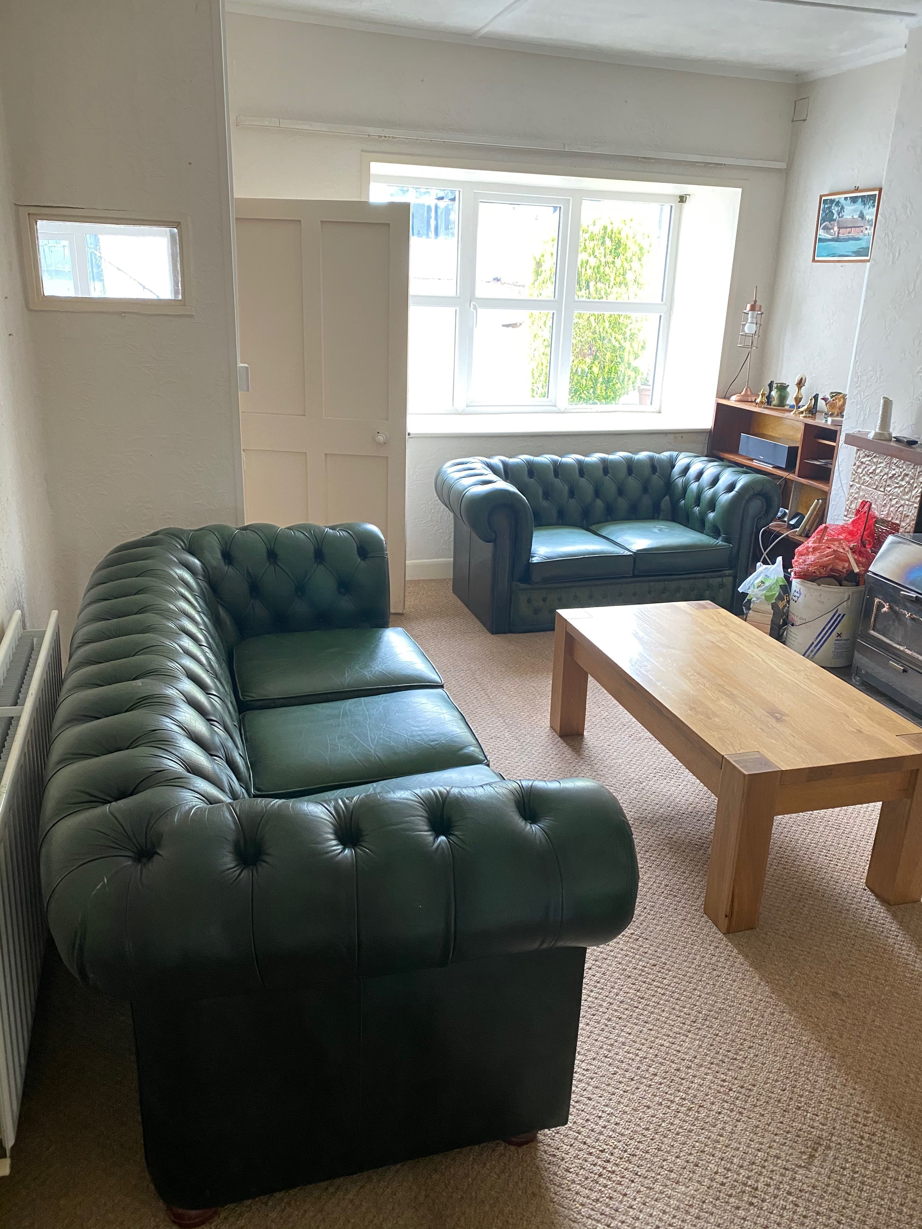 The cottage sitting room furnished near the end of the works — green leather Chesterfields and an oak table brought from Bollington.