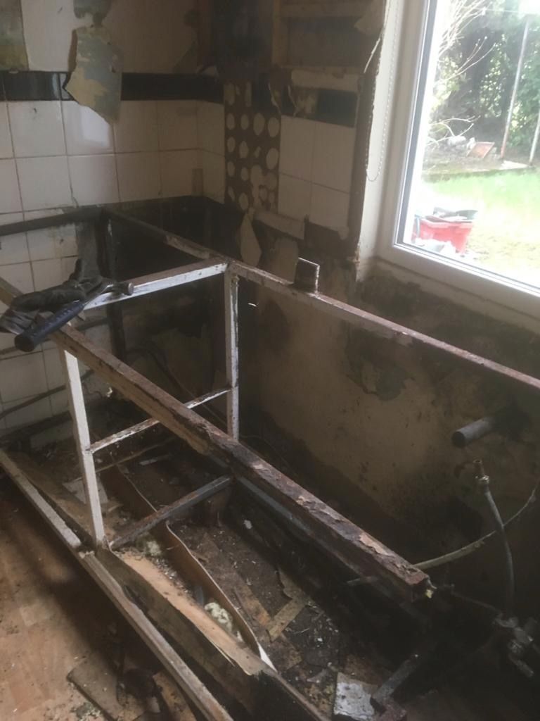 The welded iron sink support left standing after the tiling came off — the bracket DJ made at the forge.