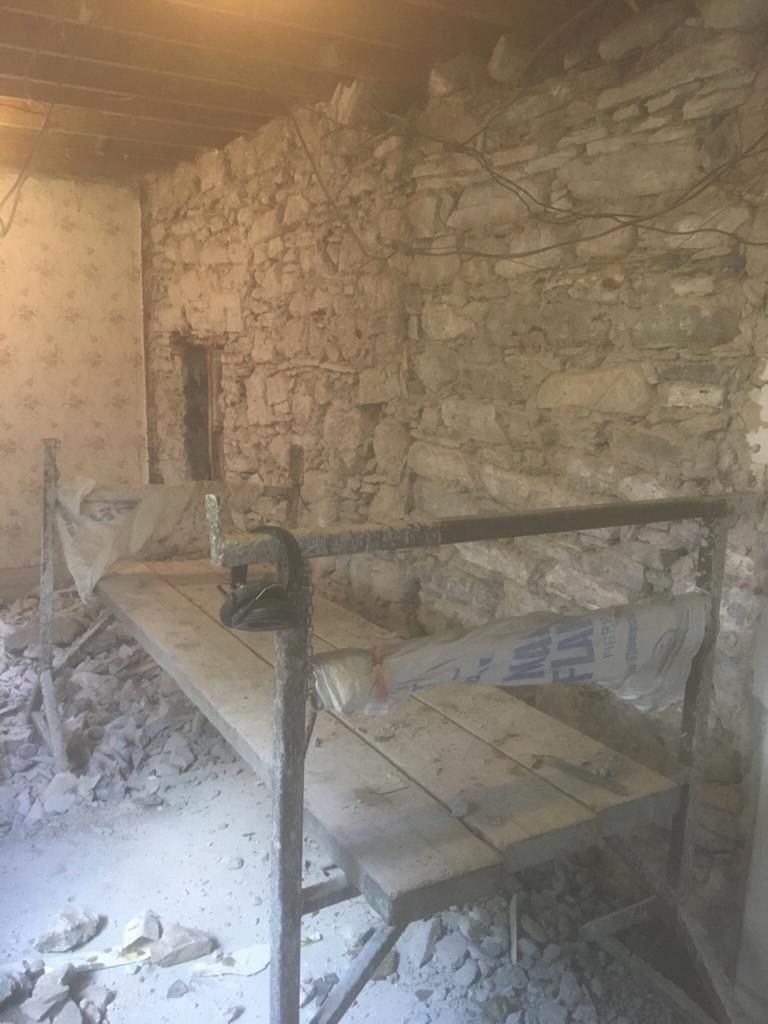 The cleaned and repointed rubble-stone wall, cleared to become the feature wall of the kitchen.