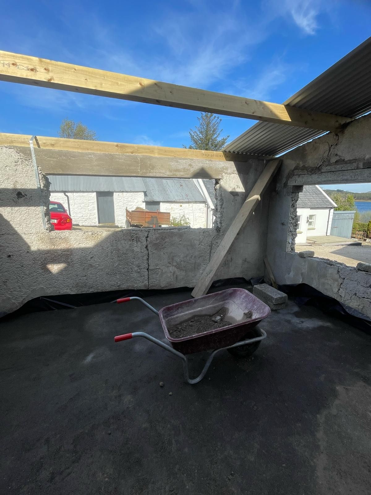 Inside the forge shell on a bright day, the street-side window widened with a new lintel, Mulroy Bay glimpsed across the courtyard.