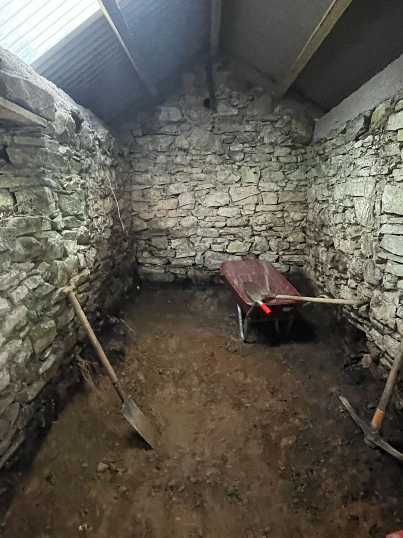 The old peat shed stripped back to bare stone and earth, before the sauna went in.