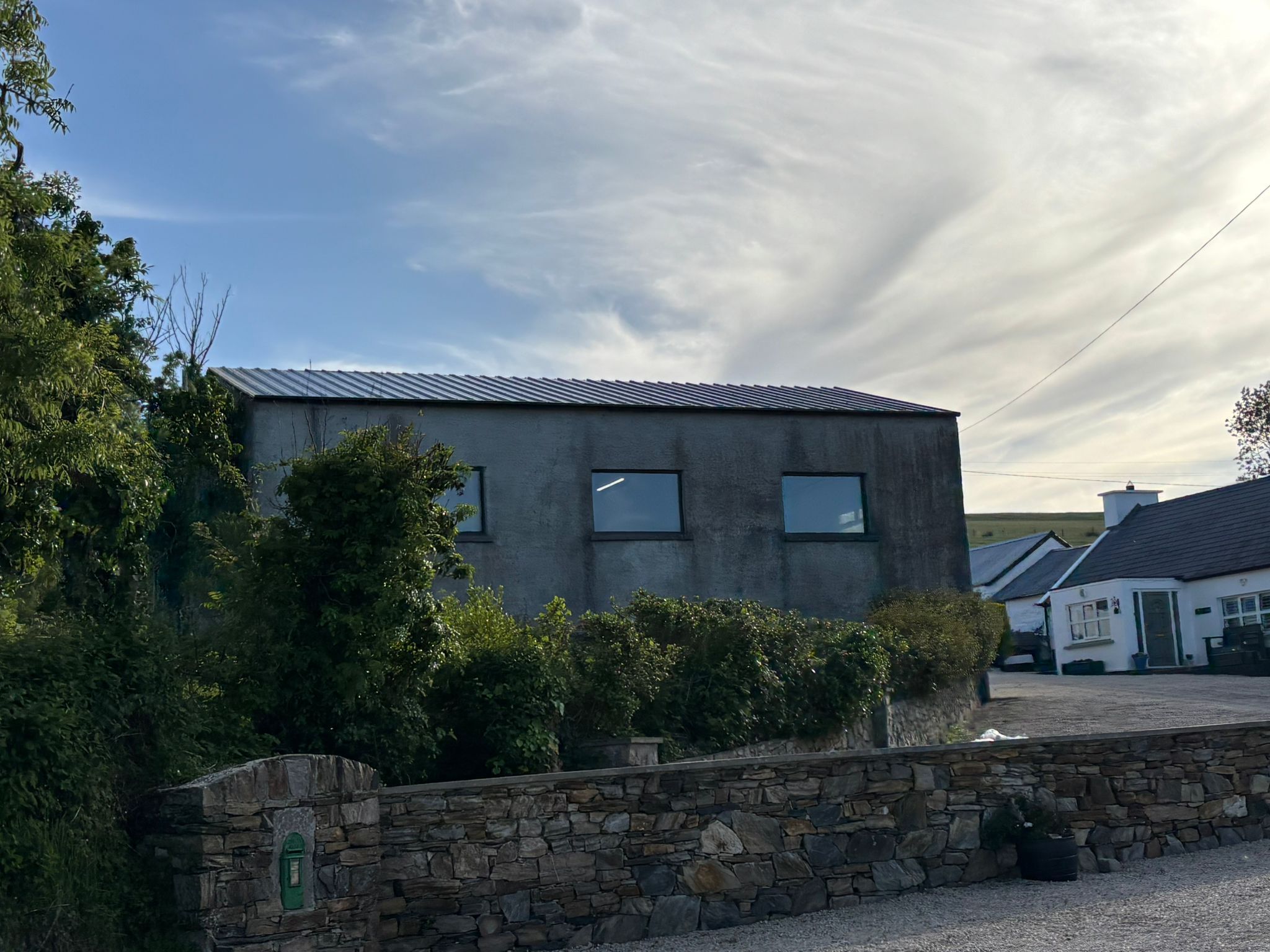 The workshop with its new dark roof, beside the games room, in evening light.