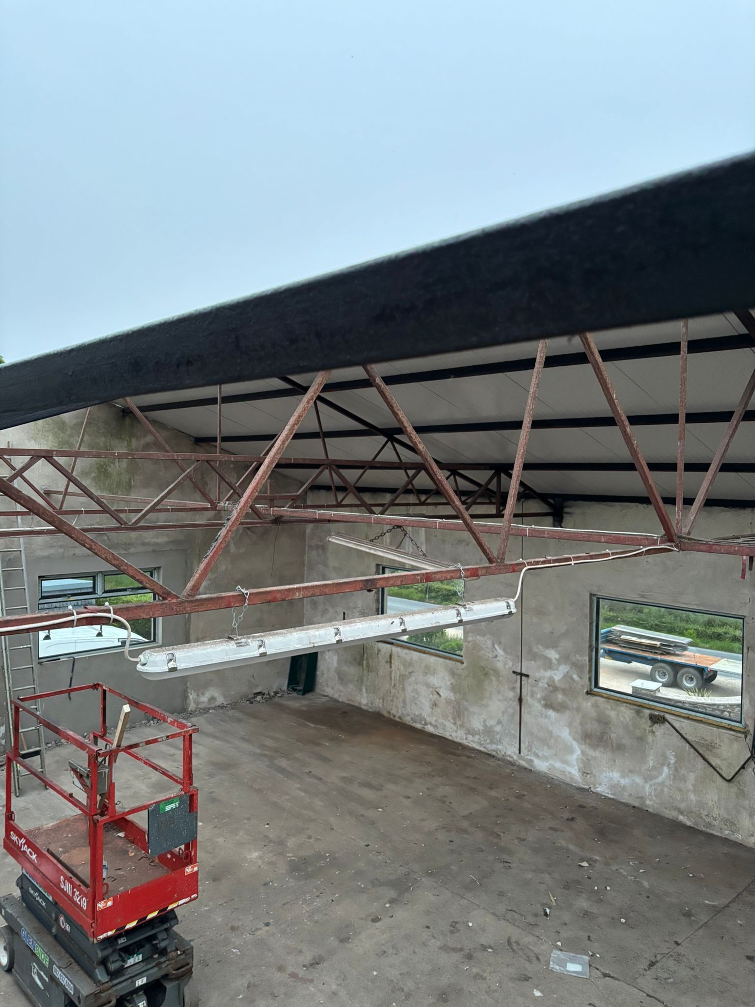 The workshop's steel frame with the roof open during the re-roof, before the new Kingspan insulated panels go on.