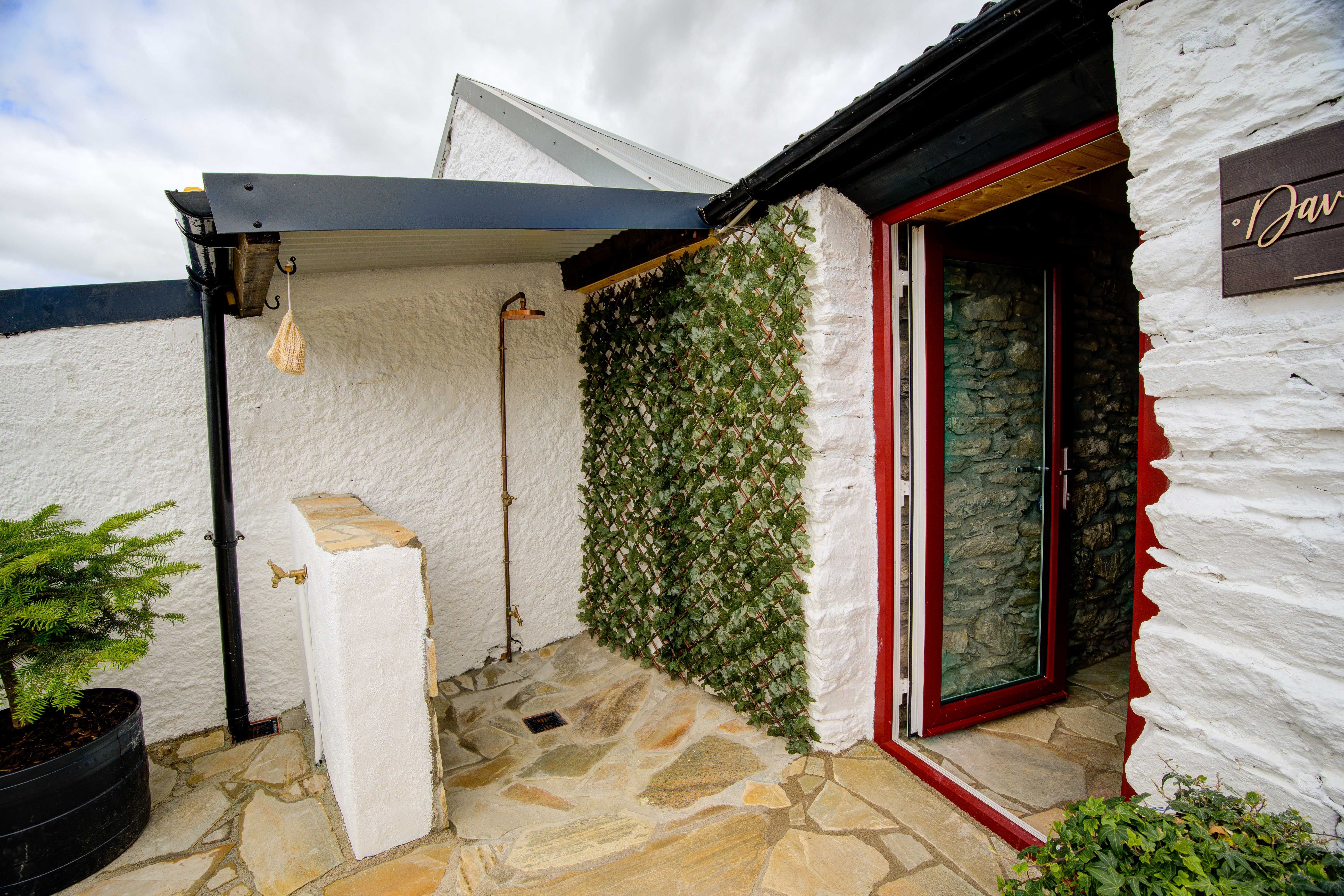 The sauna gable with the shower door open onto the courtyard.