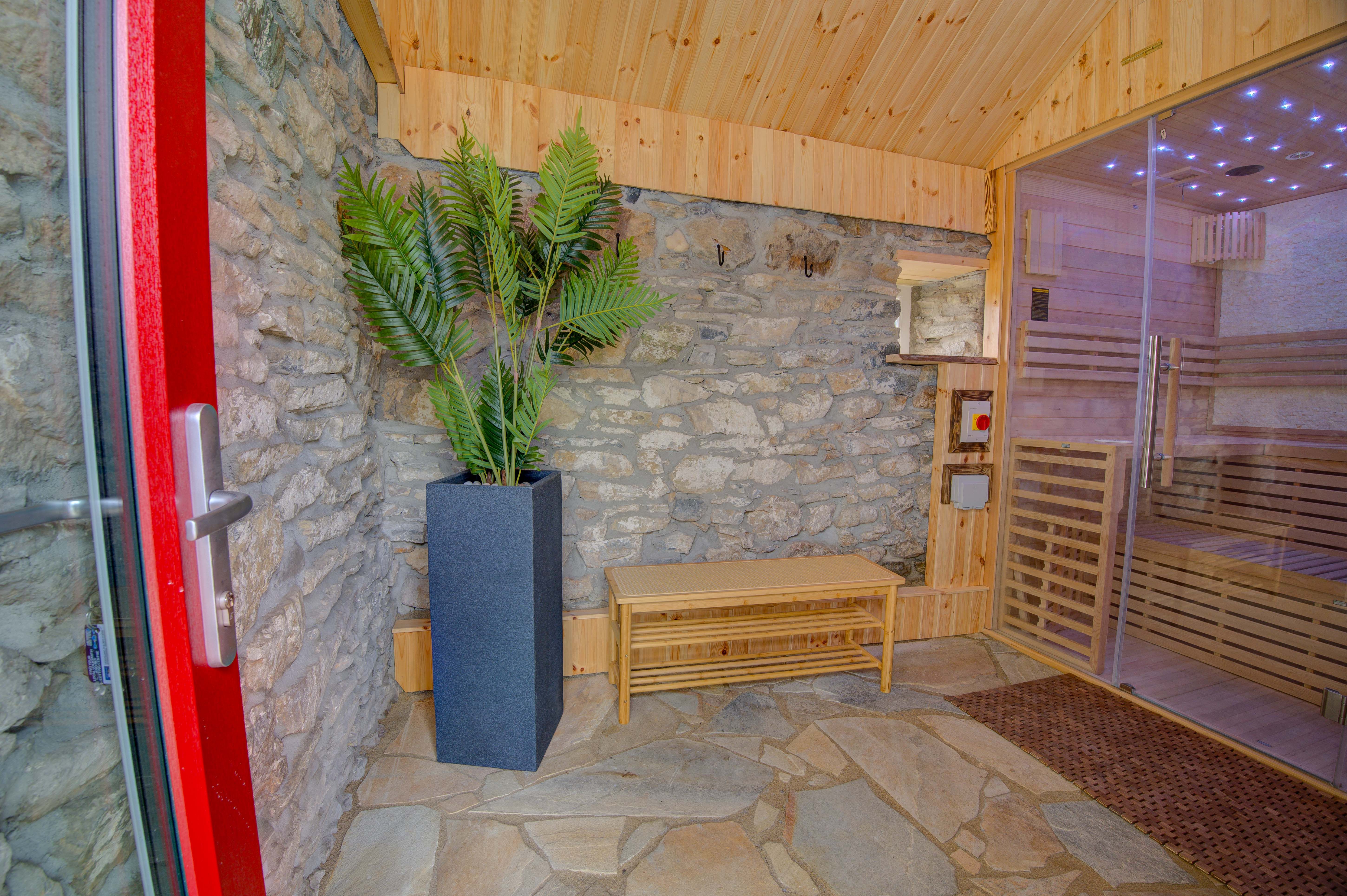 The sauna anteroom from the door, the glass cabin and starfield glowing beyond